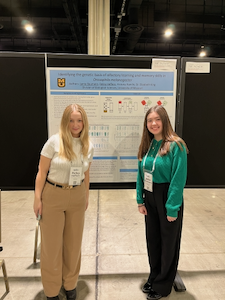 Photo of two students in front of a scientific poster.